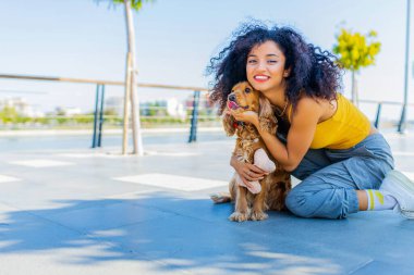 Makyajlı ve kıvırcık saç stili harcayan çok kültürlü bir kadın. Güneşli bir günde altın renkli Amerikan Cocker köpeğiyle mutlu zamanlar geçiriyor. .