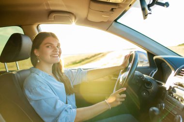 Güzel bir kadın yaz günü araba sürerken şarkı söylüyor..