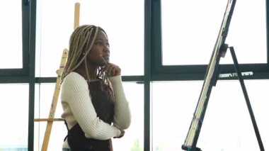 Sanat sınıfındaki Afrikalı Amerikalı kadın öğrenci ilham aldı ve resim yaptı..