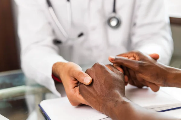 Friendly doctor hands holding patient hand support and hope concept.