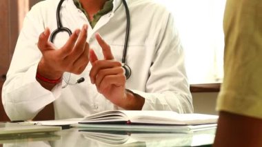 Doktor ve erkek hasta daha fazla tedavi için ofis danışmanlığında konuşuyorlar.