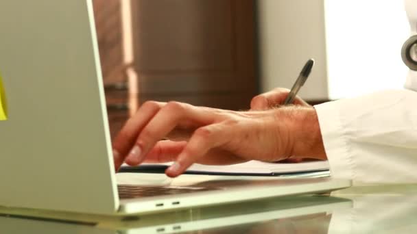 印度医生 穿着制服 在手提电脑医疗文件上记笔记 — 图库视频影像