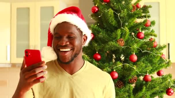 Lateinamerikanischer Mann Mit Weihnachtsmütze Unterhält Sich Videoschaltung Mit Einem Glas — Stockvideo