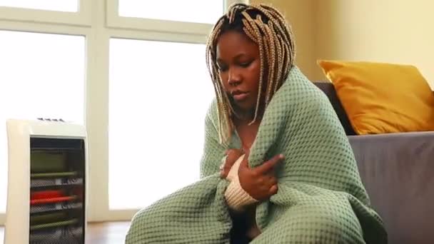 Mavi Battaniyeli Afrikalı Kadın Elektrikli Isıtıcının Yanında Isınıyor — Stok video