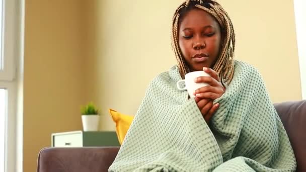 青い毛布に包まれたアフロの女リビングで熱いお茶を飲んで — ストック動画
