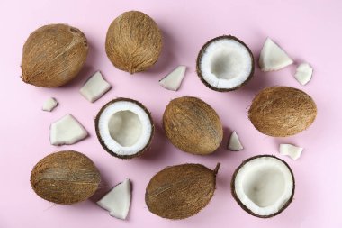 Hindistan cevizlerinin üst görüntüsü, kağıt üzerinde yarıya bölünmüş ve yarıya bölünmüş arka planda metin için bir sürü fotokopi alanı var. Tropik palmiye ağacının çiğ meyveli arka planı. Düz yatıyordu.