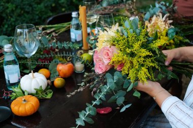 Ziyafet masası düzenleme ve düzenleme. Çiçeklerle süslenmiş güzel bir tatil masası. Kapat, kopyala boşluk, arkaplan.