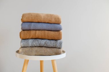 Bir sürü örülmüş pastel renkli süveter farklı örgü desenleri yığılmış, açıkça görülebilen doku. Şık sonbahar kış mevsimi örgü giysileri. Kapat, metin için boşluk kopyala.