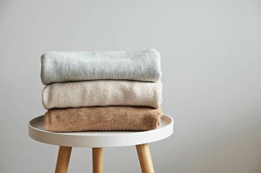 Bir sürü örülmüş pastel renkli süveter farklı örgü desenleri yığılmış, açıkça görülebilen doku. Şık sonbahar kış mevsimi örgü giysileri. Kapat, metin için boşluk kopyala.