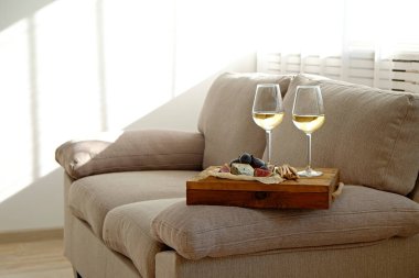 Lezzetli aperatifli iki şarap kadehi. Birkaç kadeh beyaz şarap, İtalyan ekmeği, incir ve üzüm. İç mimari. Kapat, boşluğu kopyala.