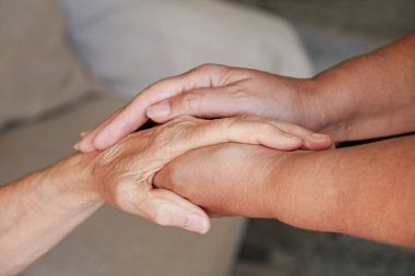 Yaşlı bakım evindeki olgun bir kadın hastane personeli hemşiresinden yardım alıyor. Yaşlı, buruşuk cilt bakımı yapan yaşlı kadın, ellerini kapat. Her gün anneanne. Arkaplan, boşluğu kopyala.