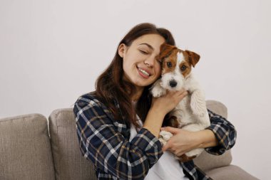 Sevimli dört aylık tel saçlı yavru köpeğiyle oynayan güzel bir kadının portresi. Sert kaplamalı sevimli kız eğleniyor. Arkaplan, kapat, boşluğu kopyala.