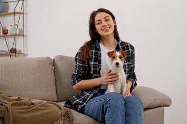 Sevimli dört aylık tel saçlı yavru köpeğiyle oynayan güzel bir kadının portresi. Sert kaplamalı sevimli kız eğleniyor. Arkaplan, kapat, boşluğu kopyala.