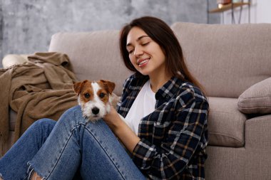 Sevimli dört aylık tel saçlı yavru köpeğiyle oynayan güzel bir kadının portresi. Sert kaplamalı sevimli kız eğleniyor. Arkaplan, kapat, boşluğu kopyala.