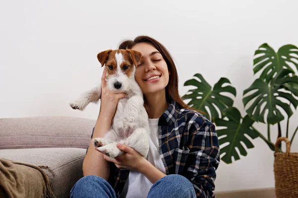 Sevimli dört aylık tel saçlı yavru köpeğiyle oynayan güzel bir kadının portresi. Sert kaplamalı sevimli kız eğleniyor. Arkaplan, kapat, boşluğu kopyala.