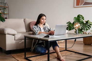 Çevrimiçi eğitim kavramı. Dizüstü bilgisayarında yazan güzel esmer bir kadın. Evde okuyan bayan üniversite öğrencisinin portresi. Kapat, kopyala boşluk, arkaplan.