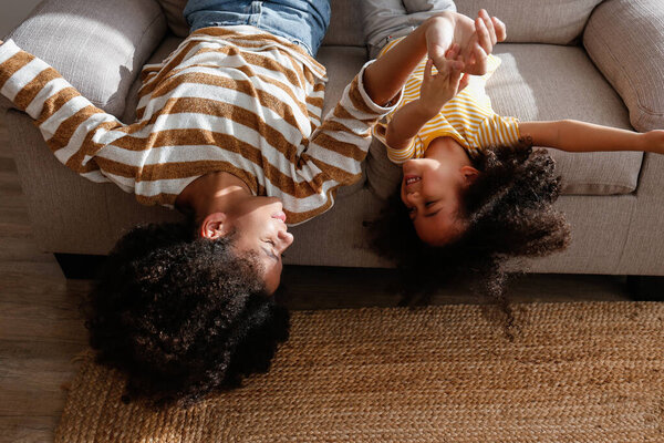 Younger and older sister spending time together at home. Two black girls of different age messing around and playing. Black female siblings having fun and bonding. Background, copy space, close up.