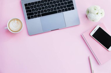 Kırpılmış çekim ya da dizüstü bilgisayar klavyesi, köpüklü kapuçino, boş ekran telefon ve küçük bir buket ranunculus çiçeği. Kapat, üst görünüm, arkaplanı kopyala.