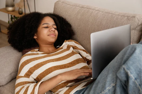 Svart Tonåring Flicka Med Afro Frisyr Ligger Soffan Bläddrar Internet — Stockfoto