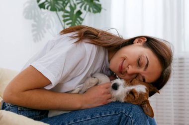 Sevimli dört aylık tel saçlı yavru köpeğiyle oynayan güzel bir kadının portresi. Sert kaplamalı sevimli kız eğleniyor. Arkaplan, kapat, boşluğu kopyala.