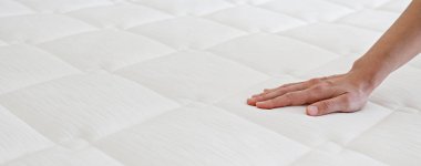 Cropped shot of young woman's hand testing white orthopedic matress on firmness. Female pressing hypoallergenic foam mattress surface to check its softness. Close up, copy space, top view, background. clipart