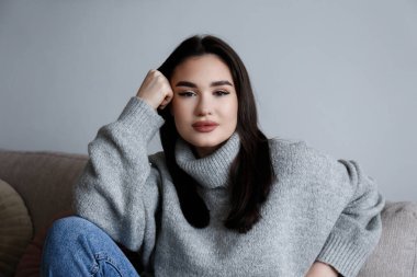 Uzun düz, kumral saçlı, büyük bir balıkçı yaka giyen güzel bir kadının portresi. Esrarengiz yüz ifadesi olan kahverengi gözlü kadın. Boşluğu, arkaplanı kopyala, kapat.