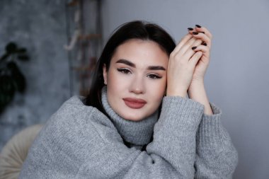 Uzun düz, kumral saçlı, büyük bir balıkçı yaka giyen güzel bir kadının portresi. Esrarengiz yüz ifadesi olan kahverengi gözlü kadın. Boşluğu, arkaplanı kopyala, kapat.