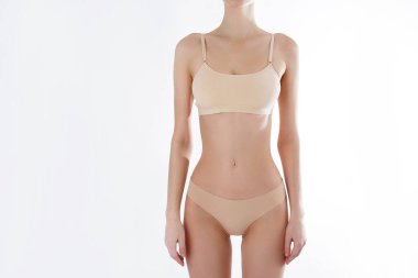 Beyaz arka planda izole edilmiş iç çamaşırlı, tanınmayan fit bir kadını yakından çek. Düz göbekli, beyaz iç çamaşırlı, zayıf, çekici bir kadın gövdesi. Metin için alanı kopyala.