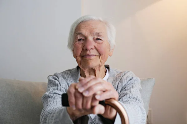 Portrait Senior Female Sitting Couch Home Leaning Cane Elderly Woman — Zdjęcie stockowe