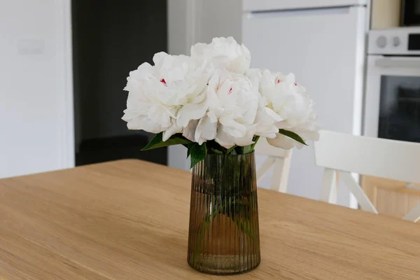 桌上的玻璃瓶里有一束漂亮的牡丹 可见的花瓣结构 艳丽的花蕾图案 顶部视图 复制空间 白墙背景 — 图库照片