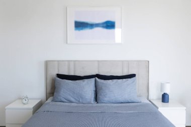 Yatak başlıklı, yeni yapılmış kral yataklı, temiz ve ütülenmiş çarşaflı, güneş ışığında şişkin yastıklı bir otel odası. Mobilya galerisinde büyük boy yatak. Kapat, metin için boşluk kopyala.