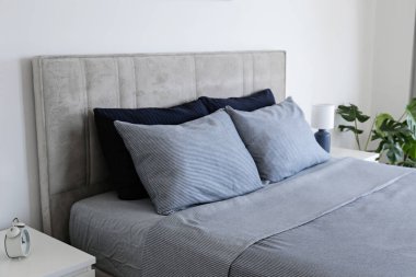 Yatak başlıklı, yeni yapılmış kral yataklı, temiz ve ütülenmiş çarşaflı, güneş ışığında şişkin yastıklı bir otel odası. Mobilya galerisinde büyük boy yatak. Kapat, metin için boşluk kopyala.