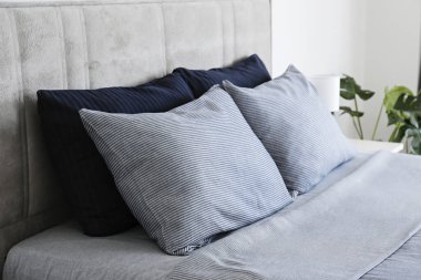 Yatak başlıklı, yeni yapılmış kral yataklı, temiz ve ütülenmiş çarşaflı, güneş ışığında şişkin yastıklı bir otel odası. Mobilya galerisinde büyük boy yatak. Kapat, metin için boşluk kopyala.