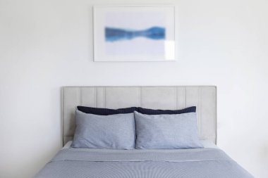 Yatak başlıklı, yeni yapılmış kral yataklı, temiz ve ütülenmiş çarşaflı, güneş ışığında şişkin yastıklı bir otel odası. Mobilya galerisinde büyük boy yatak. Kapat, metin için boşluk kopyala.