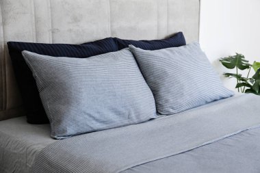 Yatak başlıklı, yeni yapılmış kral yataklı, temiz ve ütülenmiş çarşaflı, güneş ışığında şişkin yastıklı bir otel odası. Mobilya galerisinde büyük boy yatak. Kapat, metin için boşluk kopyala.