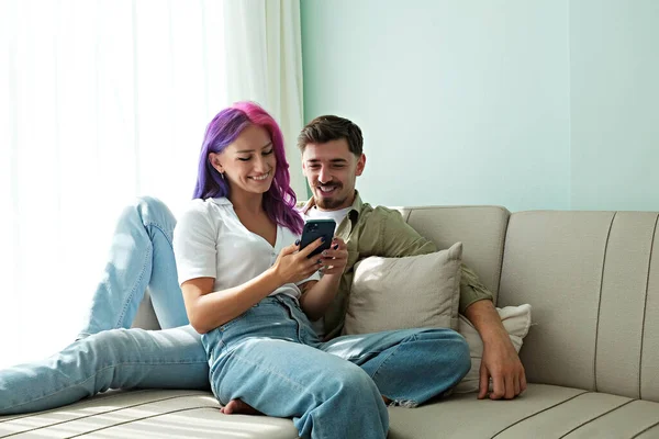 Hipster Couple Sitting Couch Laughing Memes Phone Home Young Woman — Fotografia de Stock