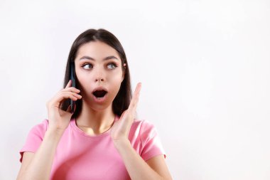 Genç ve güzel bir kadın. Çenesi açık bir yüz ifadesi var. Yüzünde boş bir ekran telefonu var. Şok olmuş, ağzı tamamen açık, inançsız bir kadın model. Arkaplan, kopyalama alanı, izole edilmiş