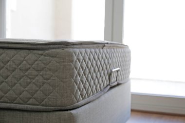 Side view of a twin sized bed with an orthopedic mattress in the children's room. Hypoallergenic foam matress for proper spinal alignment and pressure point relief. Background, copy space, close up.