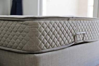 Side view of a twin sized bed with an orthopedic mattress in the children's room. Hypoallergenic foam matress for proper spinal alignment and pressure point relief. Background, copy space, close up.