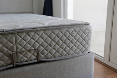 Side view of a twin sized bed with an orthopedic mattress in the children's room. Hypoallergenic foam matress for proper spinal alignment and pressure point relief. Background, copy space, close up.