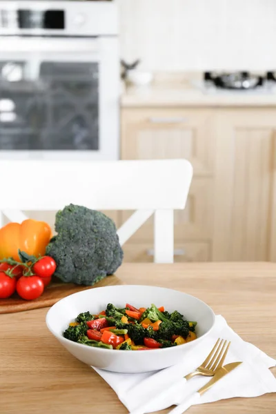 Tasty salad with steamed broccoli and fresh tomatoes in a white ceramic bowl. Clean eating concept. Healthy vegan dish made of organic vegetables. Close up, copy space, background.
