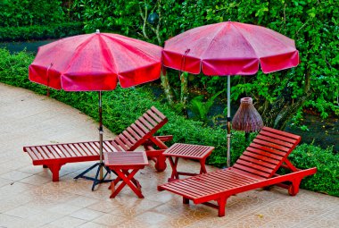 Havuzda şemsiye ile ahşap yatak