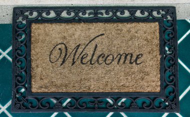 The Doormat of welcome text on floor background clipart