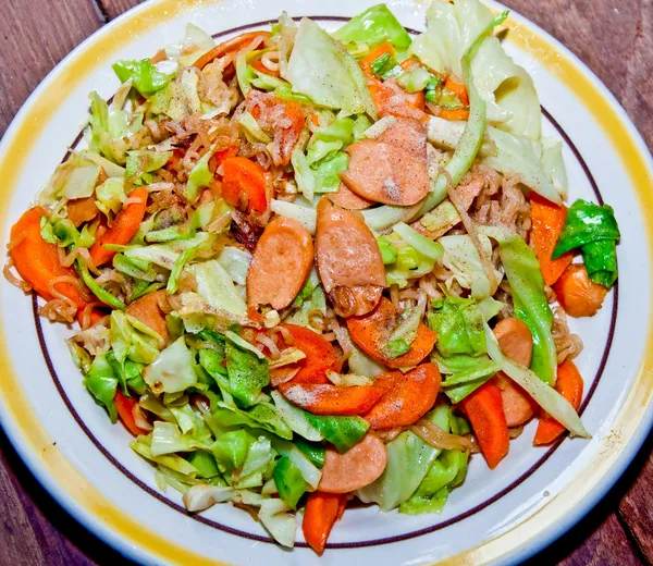 Жареная лапша с колбасой, морковкой и капустой — стоковое фото