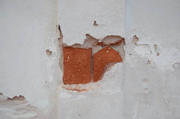Разрыв красного кирпича на фоне стены — стоковое фото