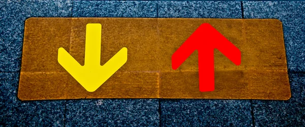 A piros és a sárga nyíl a padló háttér — Stock Fotó
