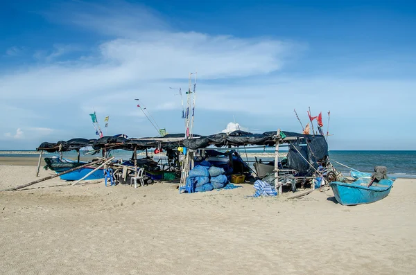 Сети и рыболовные снасти с лодкой на пляже — стоковое фото