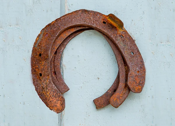 Herradura oxidada colgando de una pared — Foto de Stock