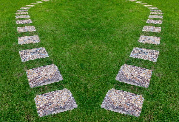 Stenen blok lopen pad in het park met groen gras achtergrond — Stockfoto