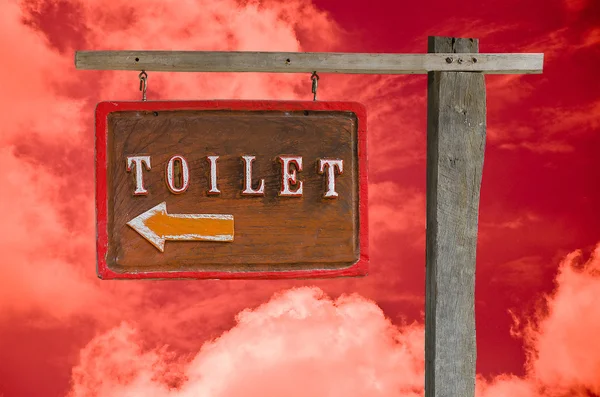 Houten teken voor toilet geïsoleerd op hemelachtergrond — Stockfoto
